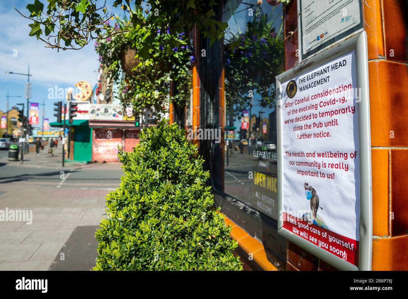 LONDRA - 22 MARZO 2020: Un cartello fuori dal pub Elephant Head a Camden Town si affaccia strade vuote durante il recente blocco di pandemia di Coronavirus. Foto Stock