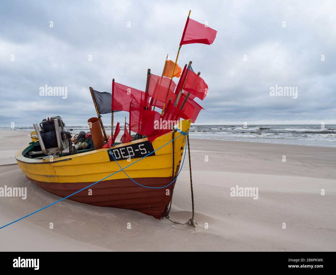Spiaggia Debki, barche da pesca colorate in riva al mare. Cielo drammatico. Mar Baltico, Polonia Foto Stock