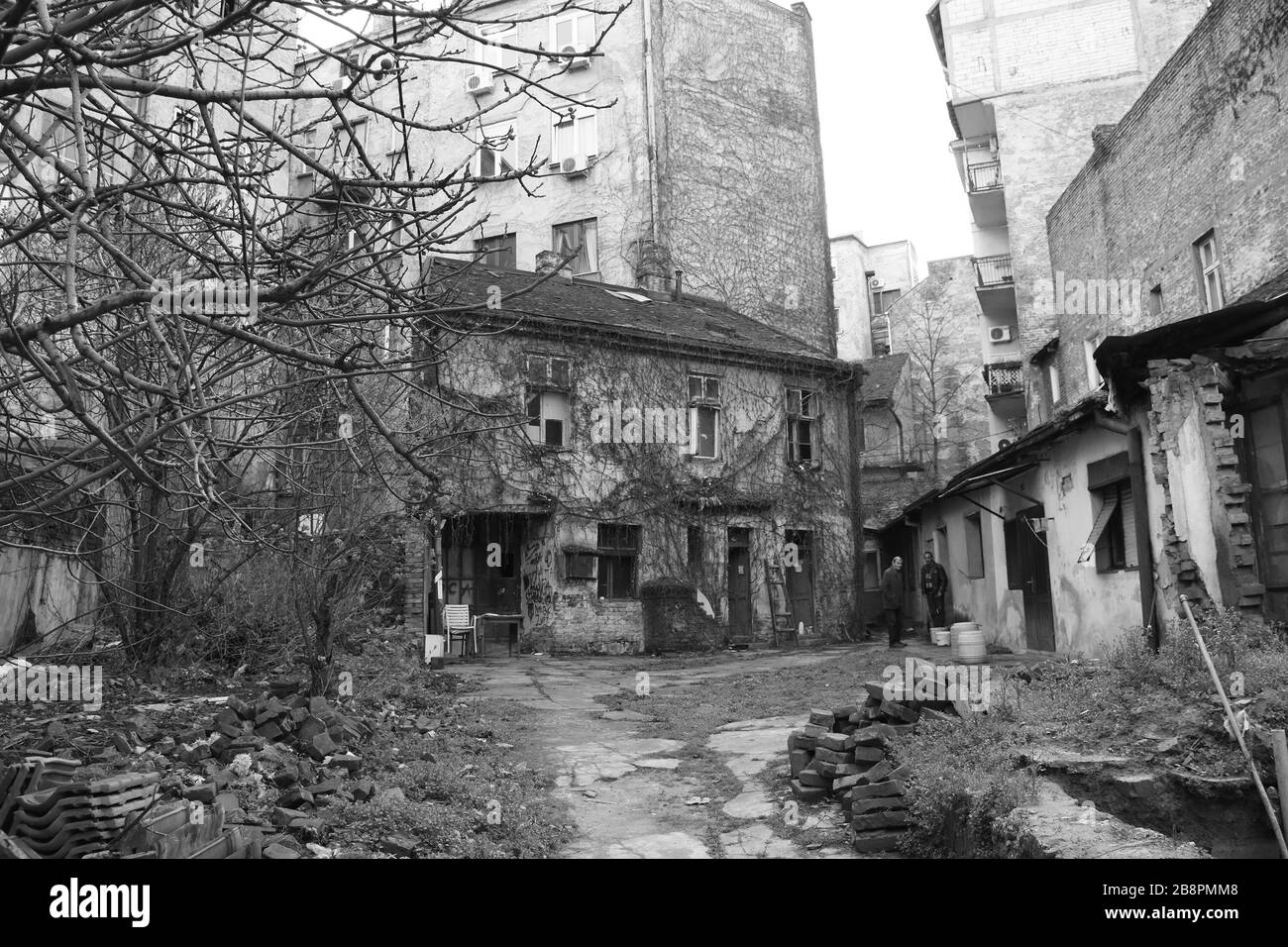 Cortile di fronte a vecchie case dilapidati. Sopra le case si trovano vecchi edifici residenziali Foto Stock