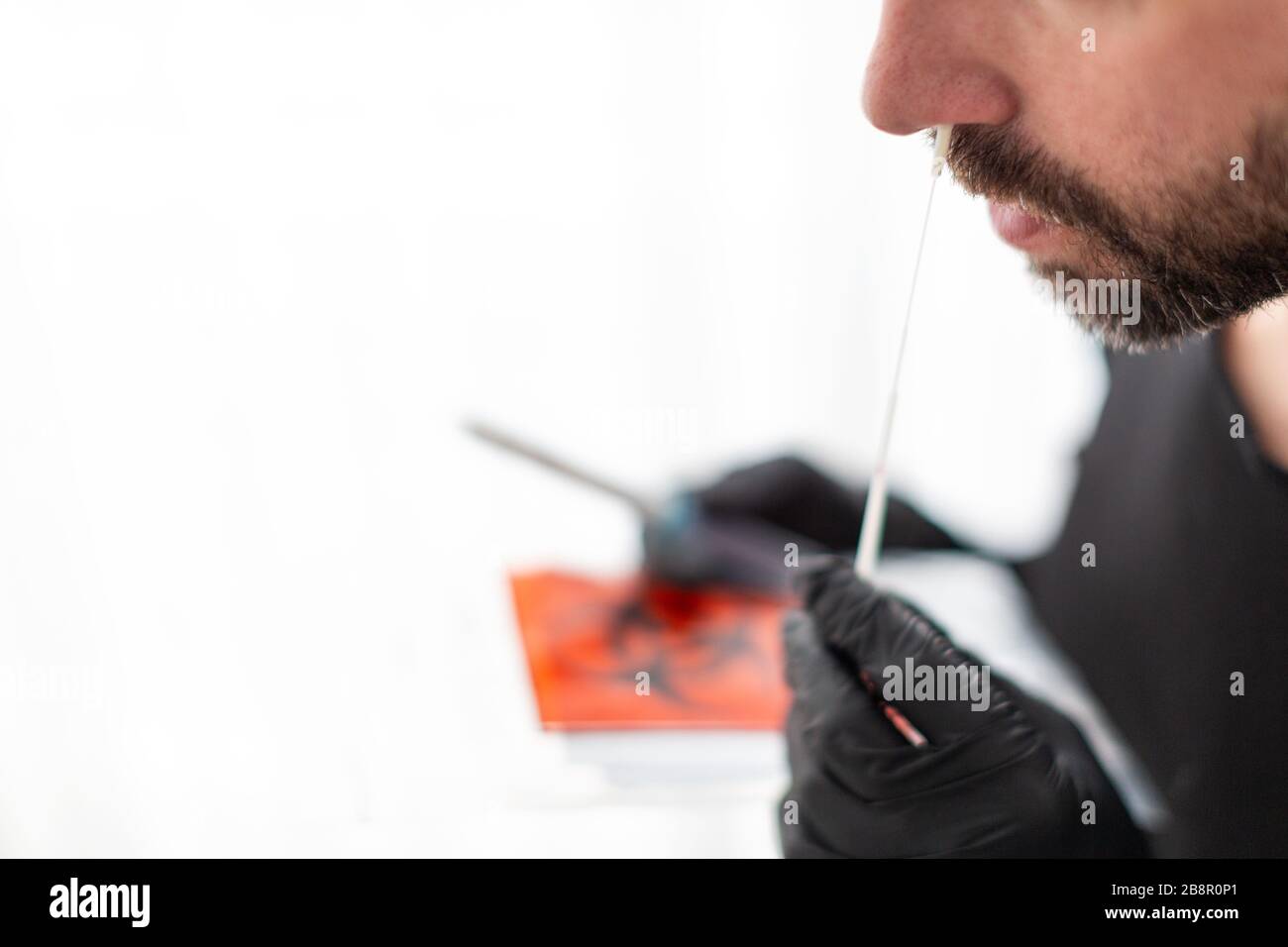 L'uomo fa con un tampone di cotone un test nasale del tampone Foto Stock