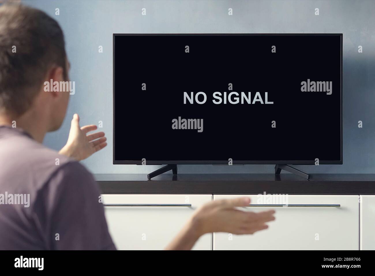 Segnale TV digitale scadente. Nessuna iscrizione di segnale sullo schermo del televisore. Il ragazzo è sconvolto dalla TV che si rompe. Foto Stock