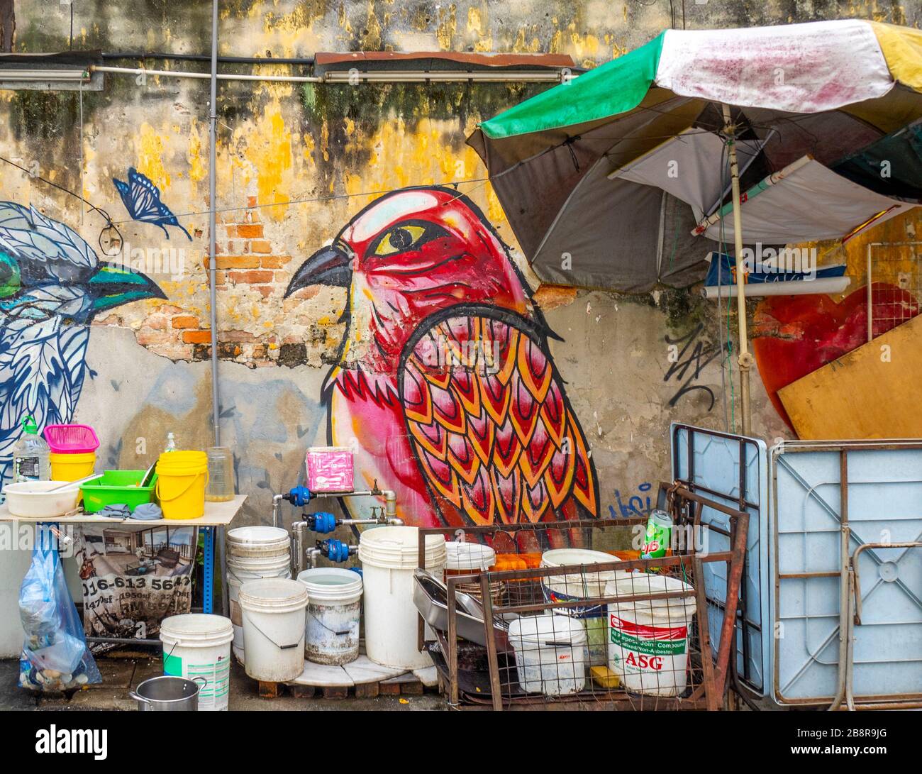 Murale di uccelli sul muro dell'edificio e cucina all'aperto di un ristorante in Lorong Panggung laneway Chinatown Kuala Lumpur Malesia. Foto Stock
