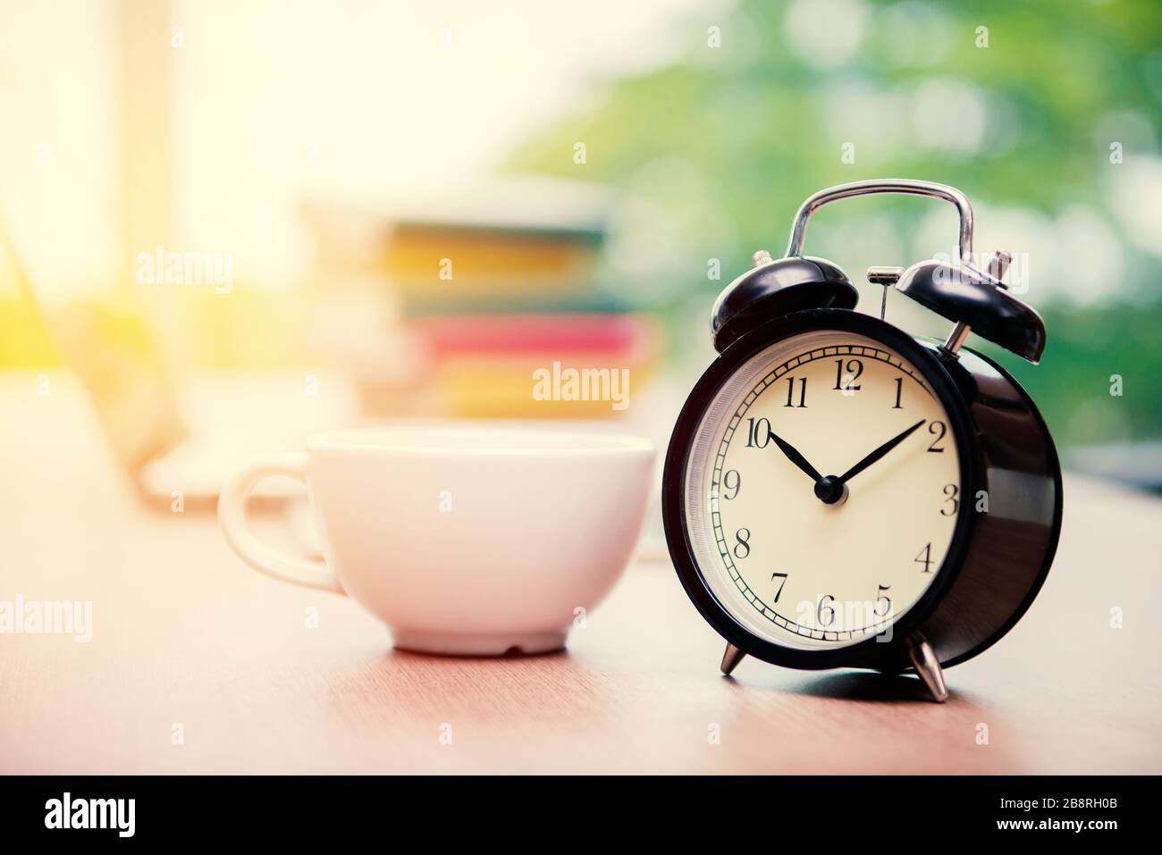 Retrò orologio sveglia con tazza di cappuccino sul tavolo in ufficio,  Coffee Break tempo Foto stock - Alamy