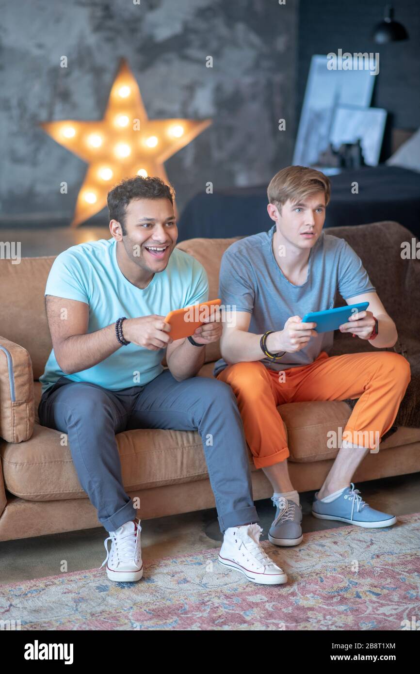 Due amici che giocano a videogiochi e si sentono fantastici Foto Stock