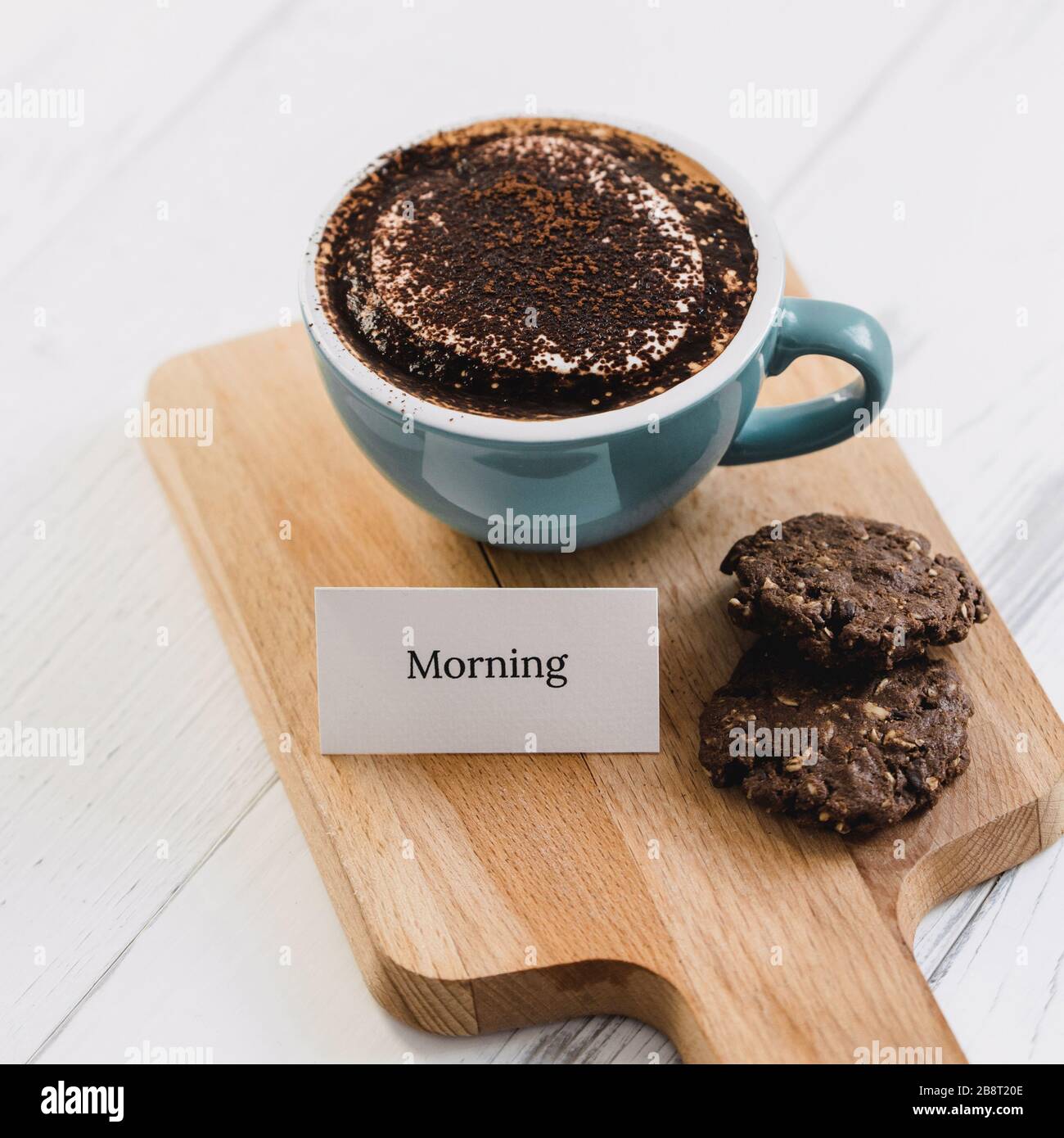 Tazza di caffè con biscotti al cioccolato fondente e messaggio di benvenuto su un piatto di legno nel caffè Foto Stock