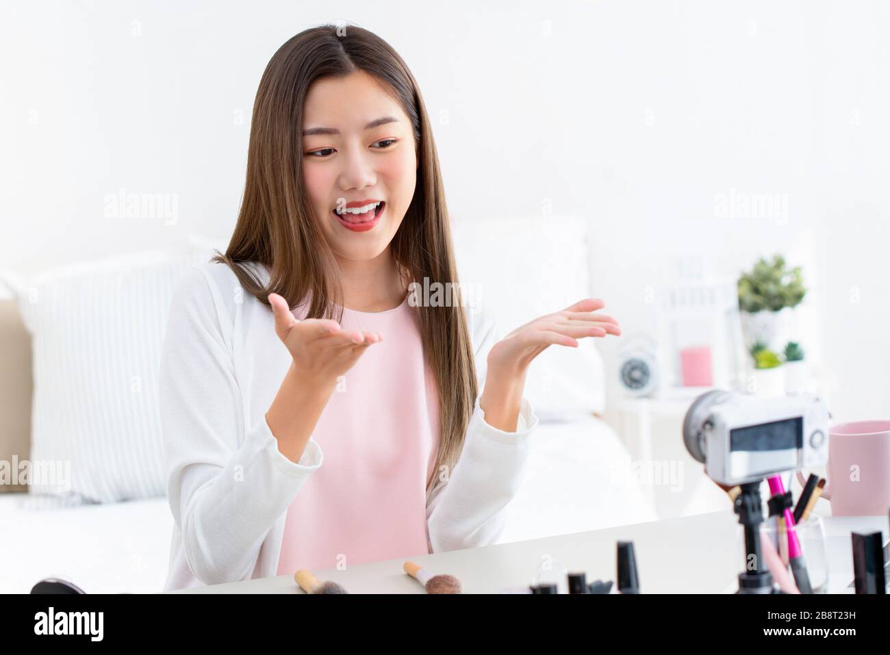 Sorridente giovane asiatica ragazza beauty influencer registrazione video con fotocamera a casa Foto Stock