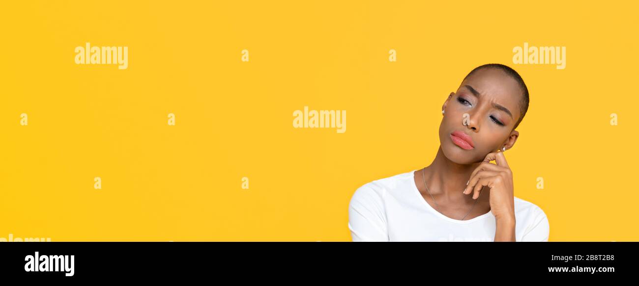 African American donna sensazione annoiato su giallo isolato banner di sfondo studio con spazio copia Foto Stock