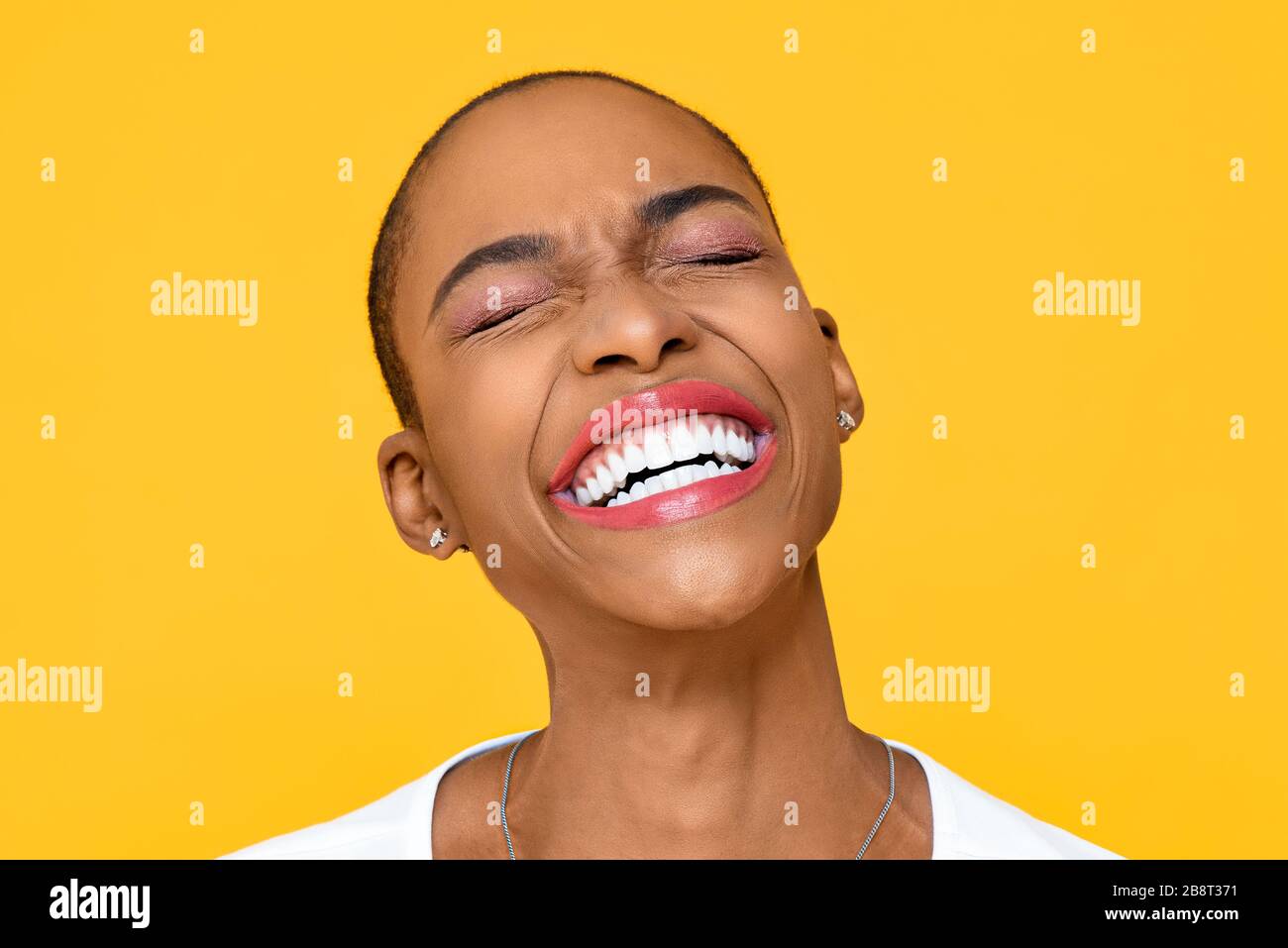Felice ecstatic African American donna sorridente con occhio chiuso isolato su sfondo giallo colorato Foto Stock