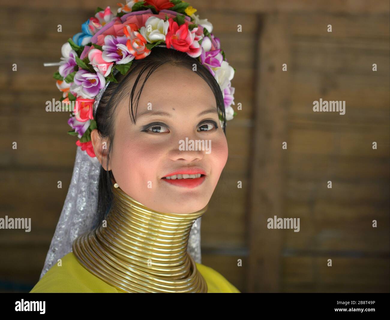 Bella tailandese / birmana lungo-collo Kayan venditore ("ragazza donna") con tribale Padaung anelli / bobine del collo in ottone sorride per la macchina fotografica. Foto Stock