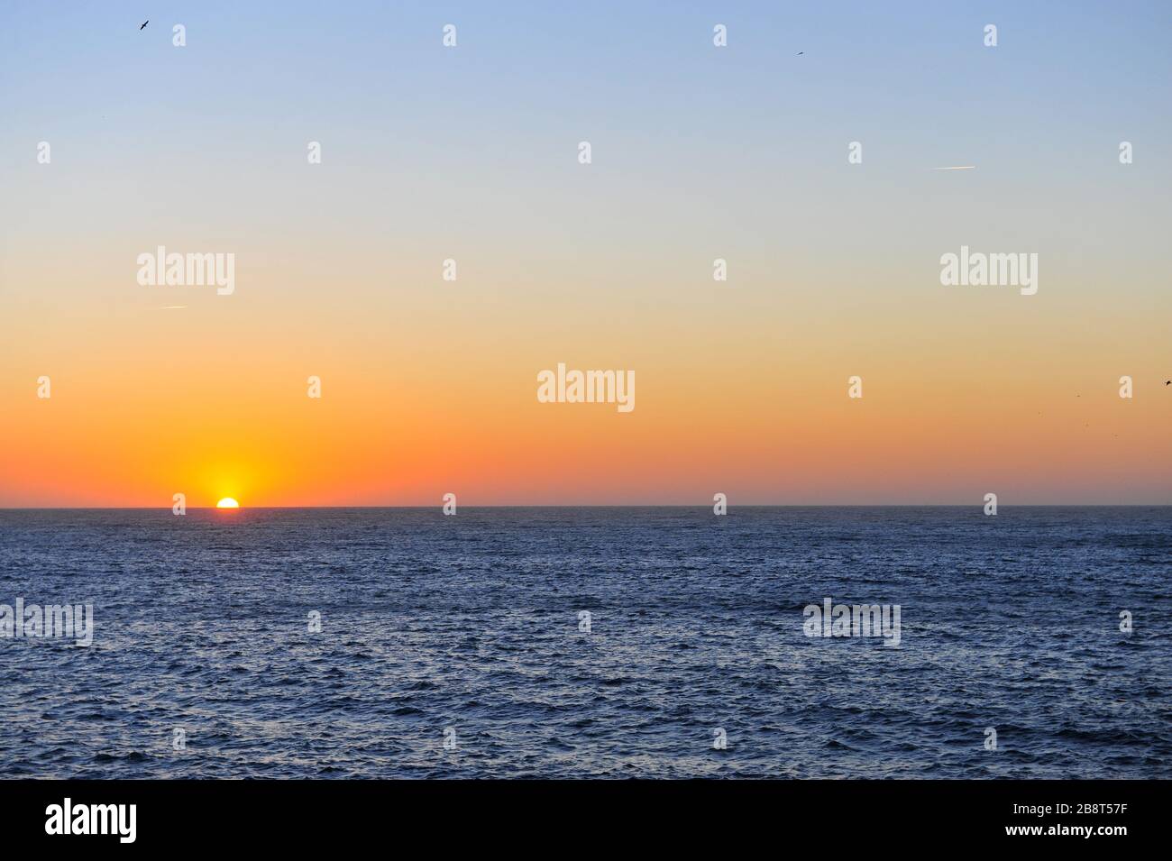 Vista panoramica del sole che scende con l'oceano blu profondo, Portogallo Foto Stock