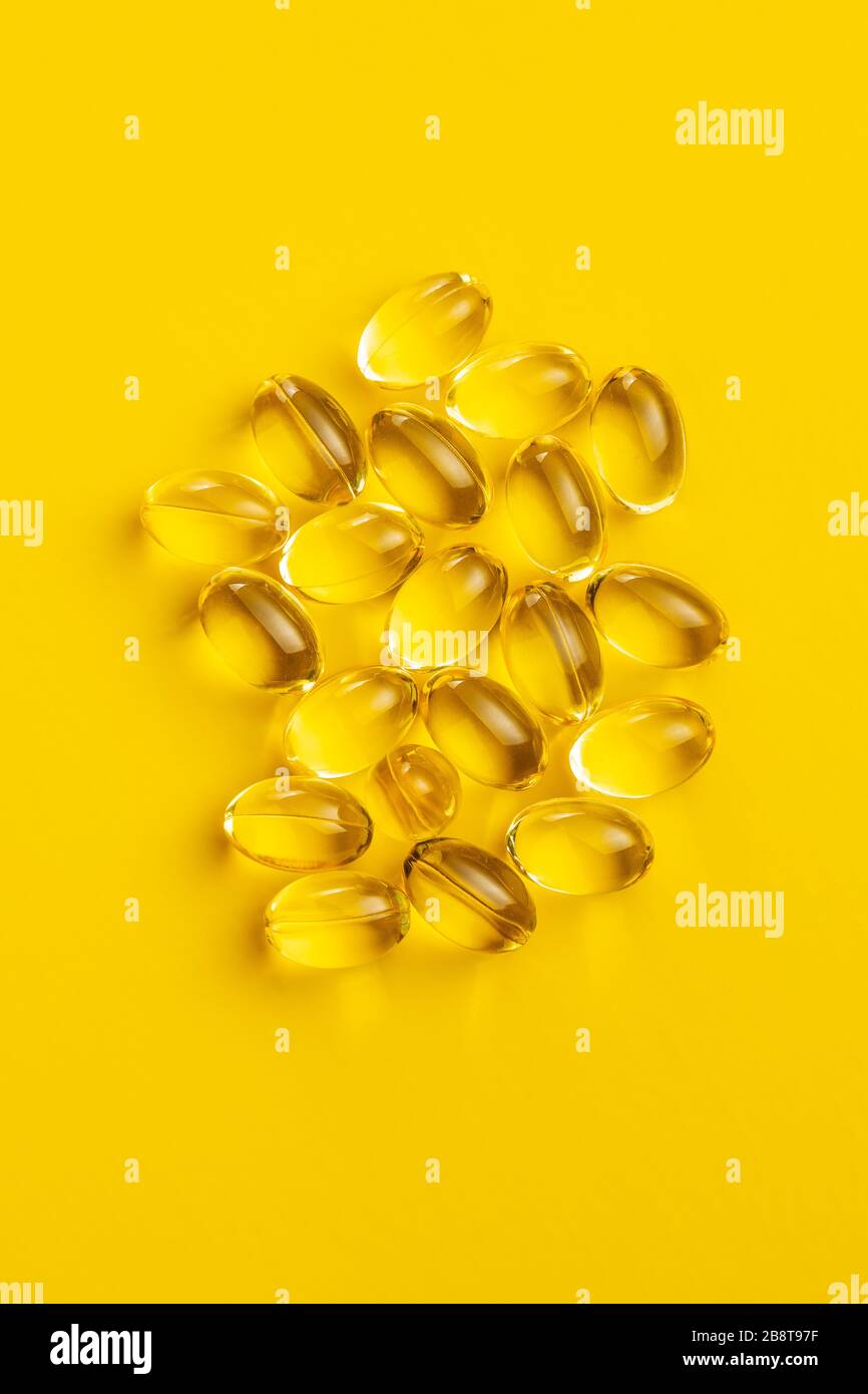 Omega 3 pillole. Capsule di supplemento di olio di pesce su sfondo giallo. Vista dall'alto. Foto Stock