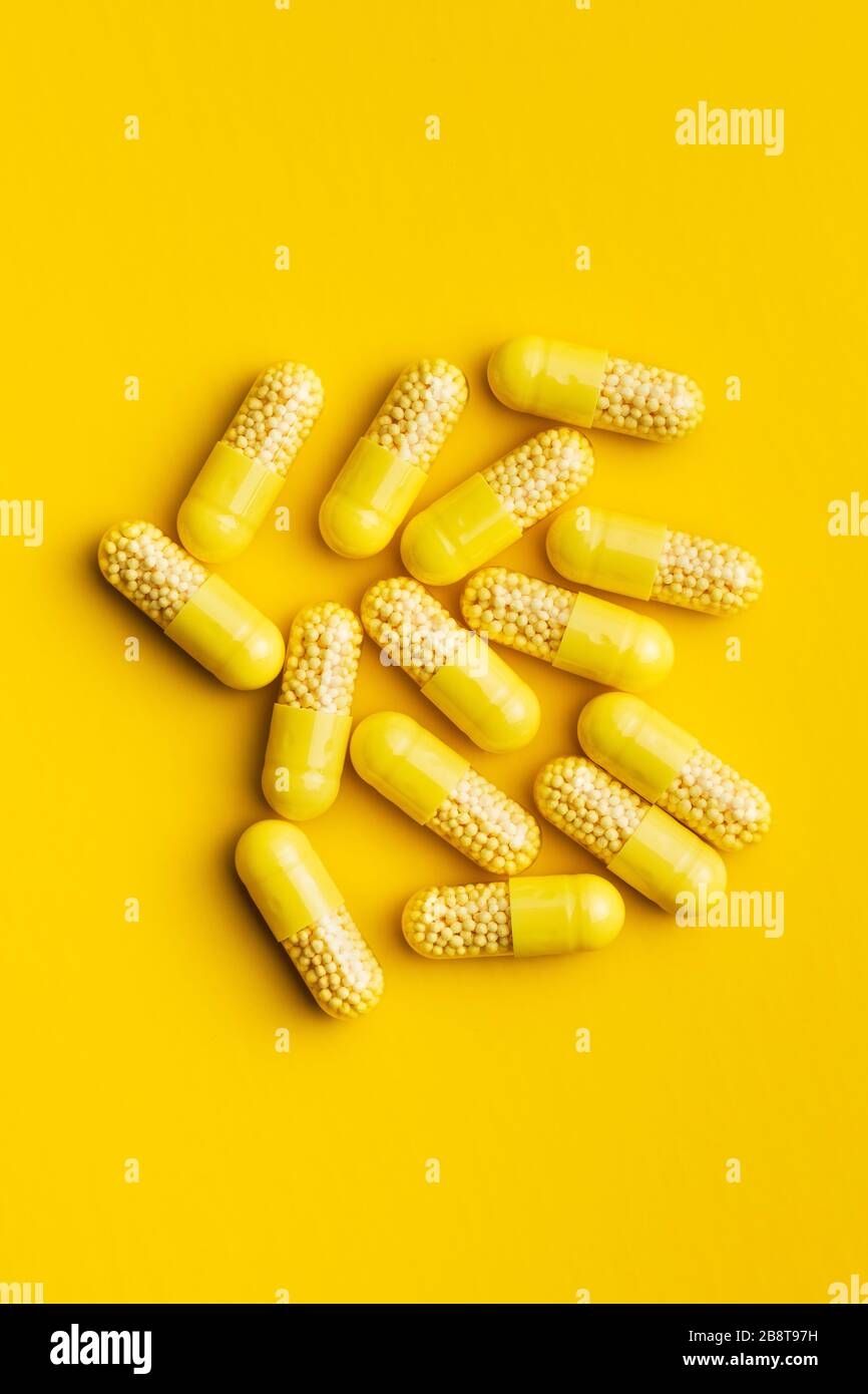 Capsule vitaminiche. Pillole di vitamina C su sfondo giallo. Vista dall'alto. Foto Stock