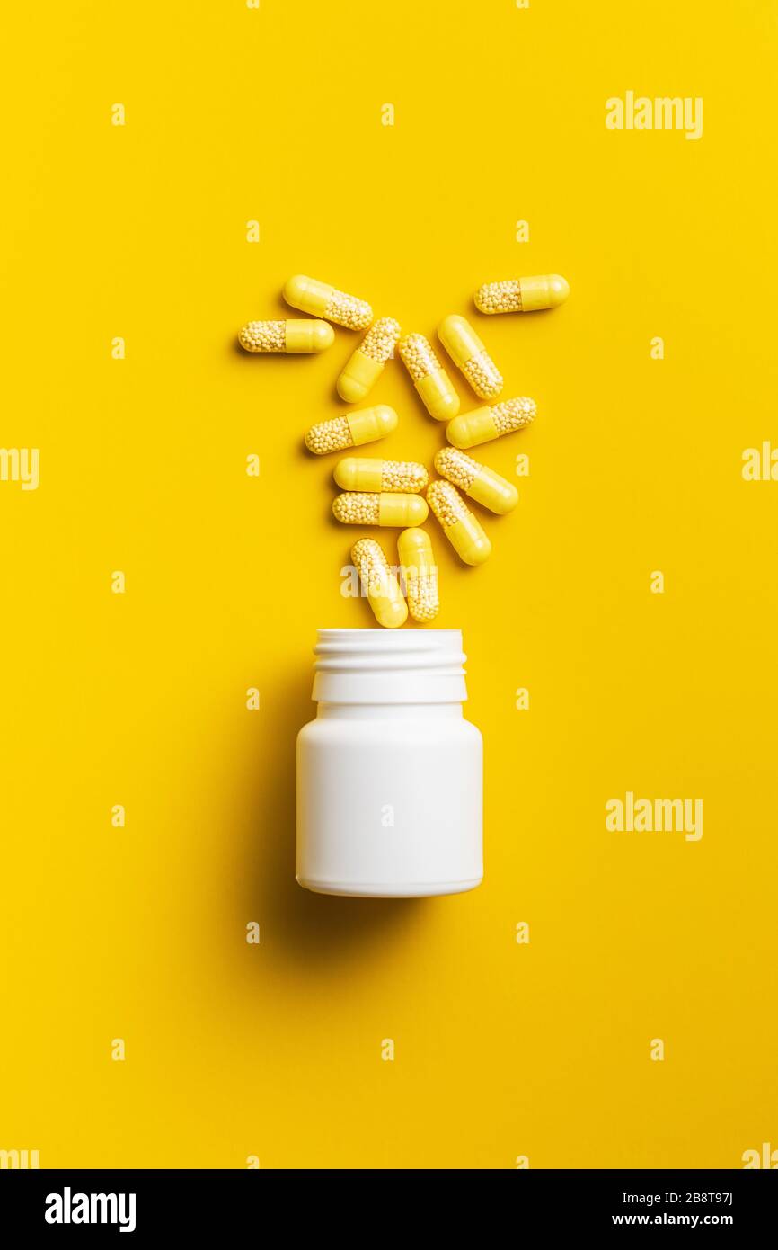 Capsule vitaminiche. Pillole di vitamina C su sfondo giallo. Vista dall'alto. Foto Stock
