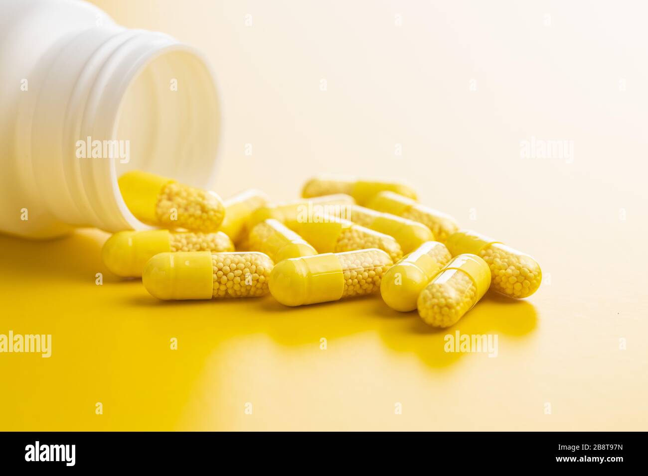 Capsule vitaminiche. Pillole di vitamina C su sfondo giallo. Foto Stock