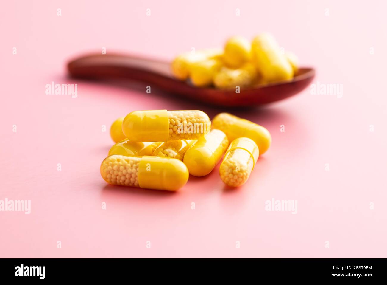 Capsule vitaminiche. Pillole di vitamina C su sfondo rosa. Foto Stock
