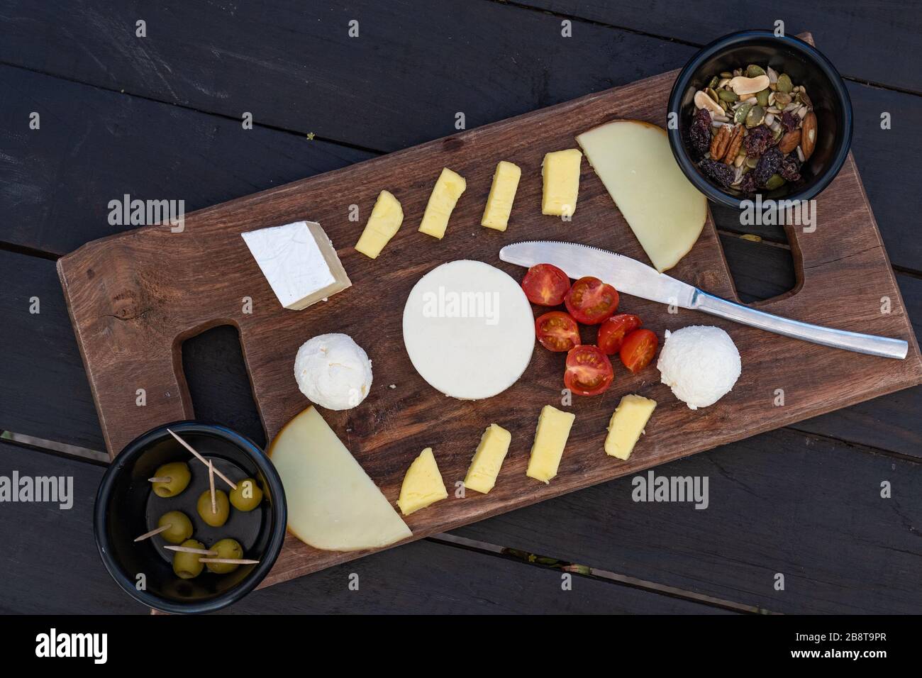 Piatto di formaggio. Assortimento di formaggi vari con noci e olive. Foto Stock
