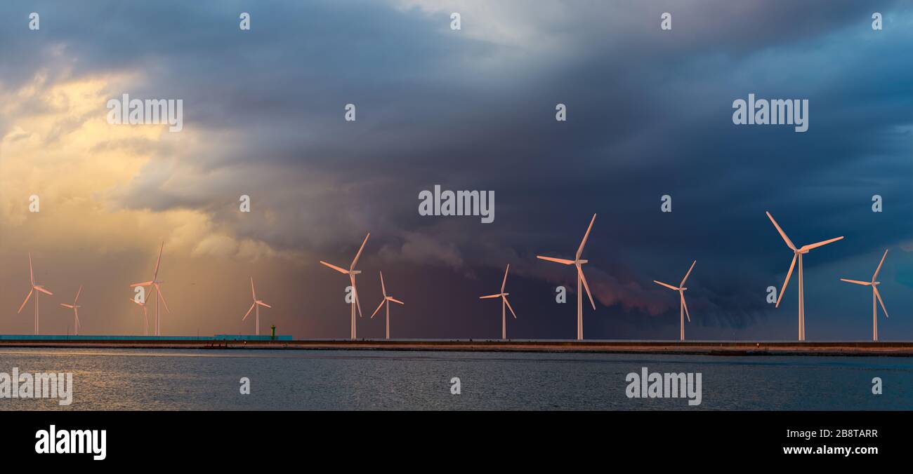 Parco eolico offshore a un bellissimo e spettacolare tramonto Foto Stock