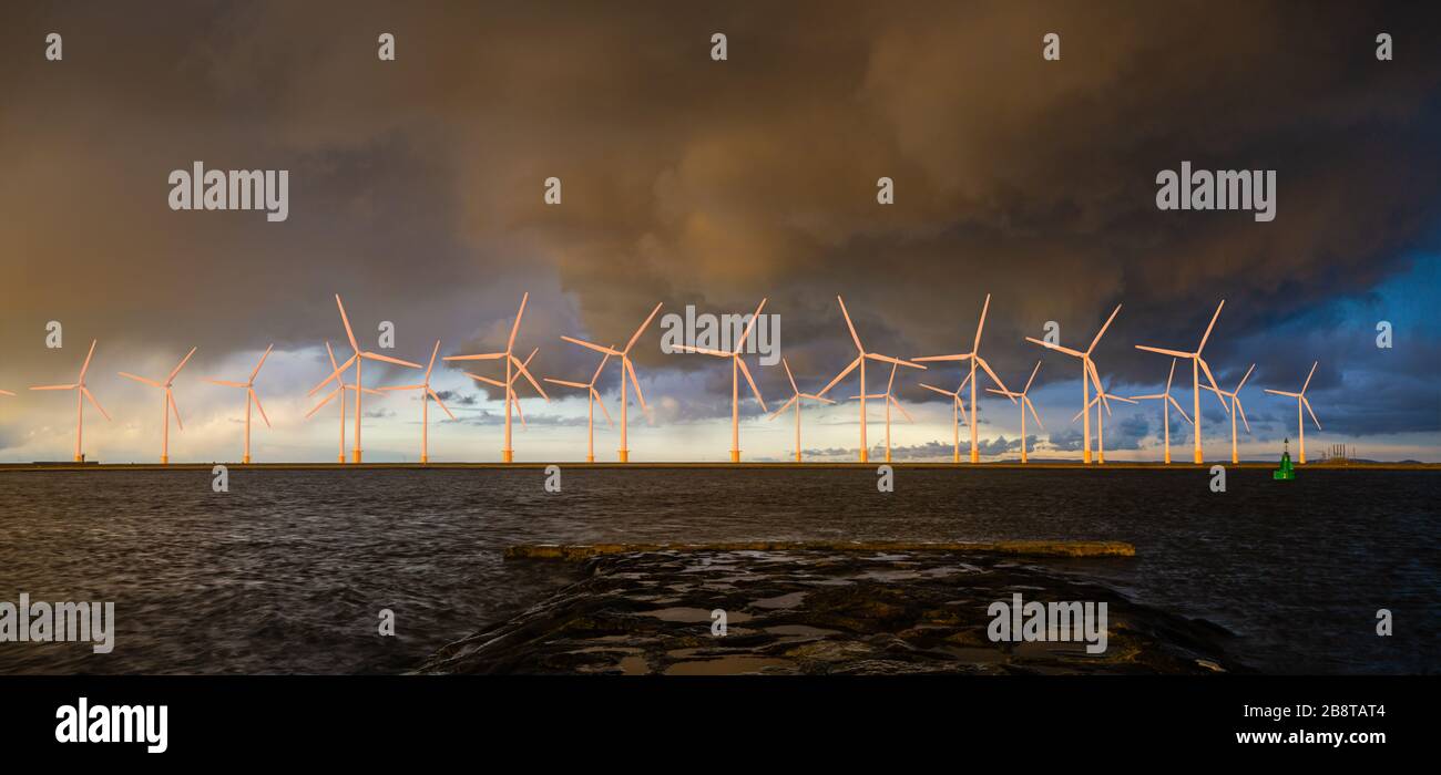 Parco eolico offshore a un bellissimo e spettacolare tramonto Foto Stock