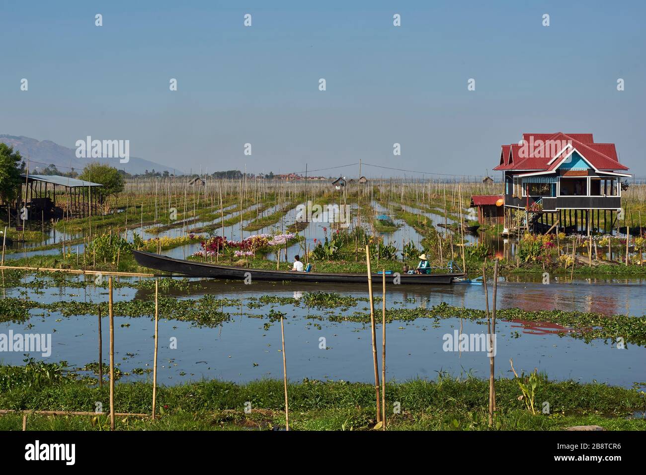Schwimmende Gärten auf dem Inle-See, Haus auf Stelzen, vorne Wasserstraße mit Boot, Shan-Staat, Myanmar Foto Stock