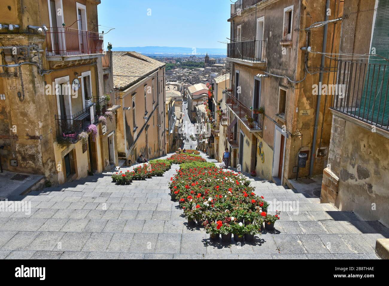 Una strada stretta tra le caratteristiche case di Caltagirone, una città in Sicilia in Italia Foto Stock