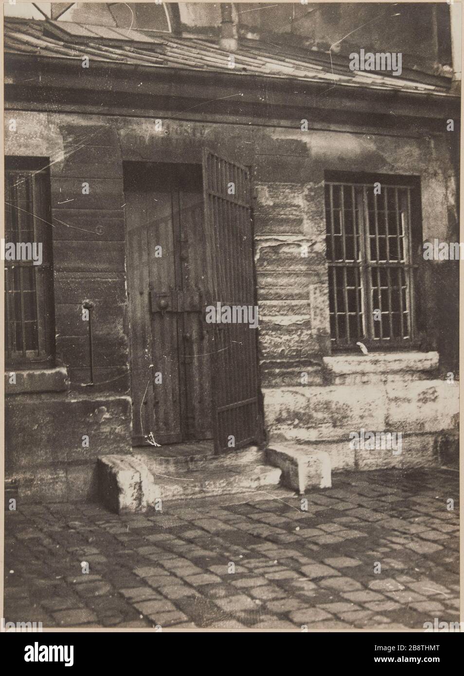 Porta anteriore dell'infermeria. Carcere di St. Lazare, carcere per le donne, 107 rue du Faubourg Saint-Denis, 10 ° arrondissement, Parigi. Porte d'entrée de l'infermerie. Carcere Saint-Lazare, maison d’arrêt pour femmes, 107 rue du Faubourg-Saint-Denis. Parigi (Xème arr.). Photographie d'Henri Manuel (1874-1947). Tire gélatino-argentique au bromure sur papier, collé sur un page d'album cartonnée. Agrandisement d’après une plaque négative sur verre. 1929-1931. Parigi, musée Carnavalet. Foto Stock