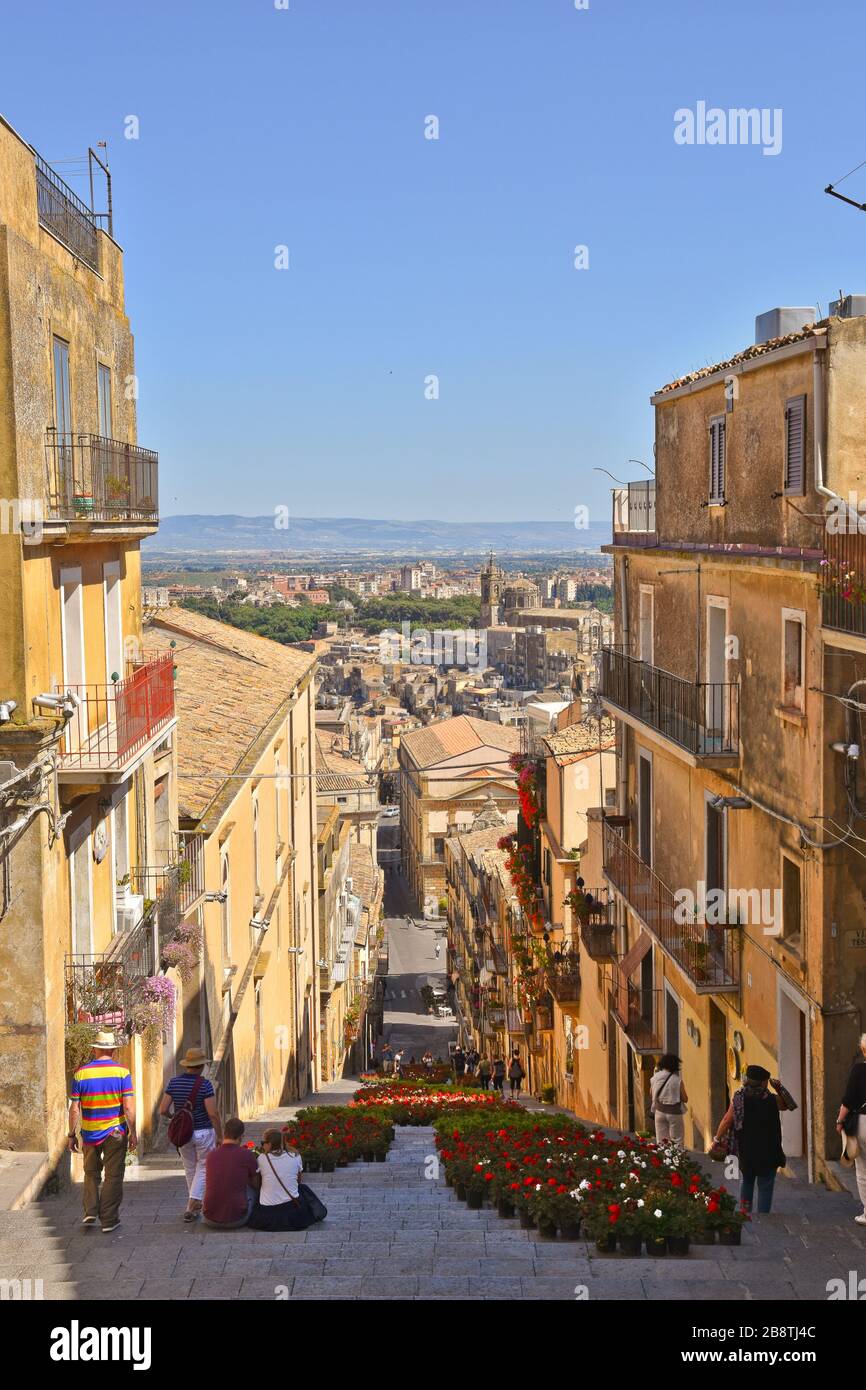 Una strada stretta tra le caratteristiche case di Caltagirone, una città in Sicilia in Italia Foto Stock