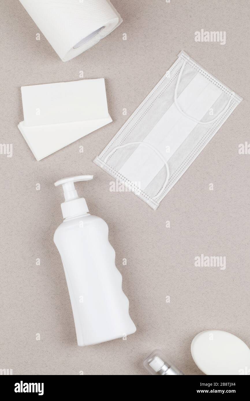 Gel antisettico, tovaglioli sanitari, maschera medica, gel antibatterico, sapone su sfondo grigio. Concetto di igiene personale protettiva. Prevenzione del coronav Foto Stock