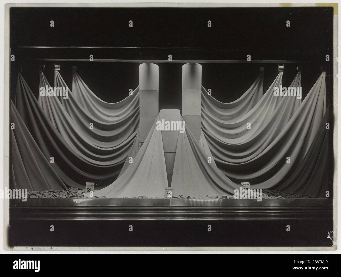 Vetrina con tessuto disteso intorno a tre rulli, grandi magazzini Printemps, boulevard Haussmann, 9 ° arrondissement, Parigi. Vitrine présentant des tissus distendus autour de trois rouleaux, magasin 'le Printemps', boulevard Haussmann. Parigi (IXème arr.). Anonima fotographie. Tigre au gélatino-bromure d’argent. Parigi, musée Carnavalet. Foto Stock