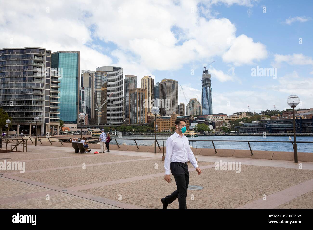 Centro di Sydney, Australia. Lunedì 23 Marzo 2020. Lavoratore in ufficio che indossa la maschera a pranzo in Circular Quay. Credit Martin Berry/Alamy Live News Foto Stock