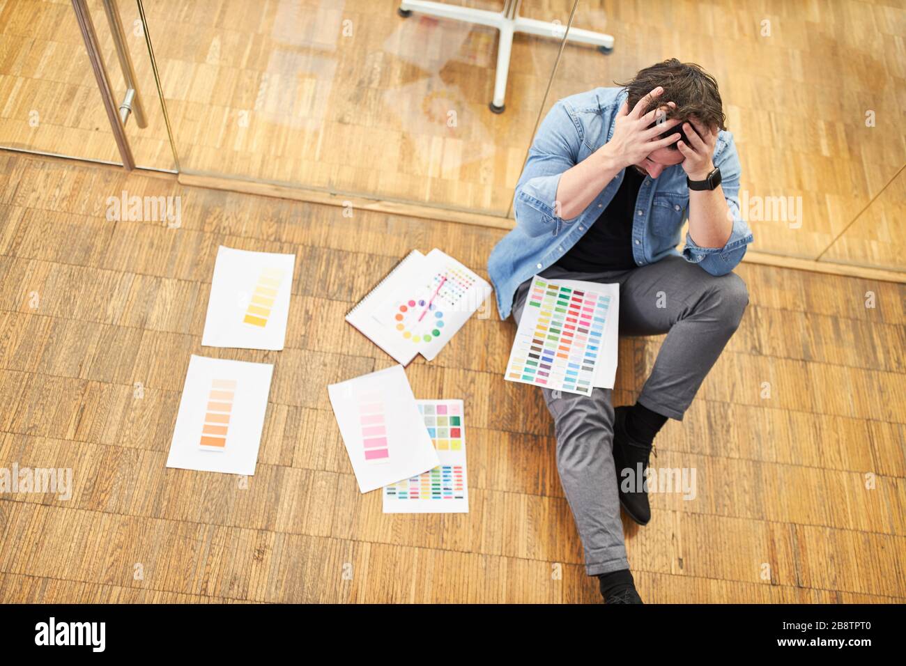 Progettista di fotoricettore disperato o progettista grafico con un'emicrania o burnout Foto Stock