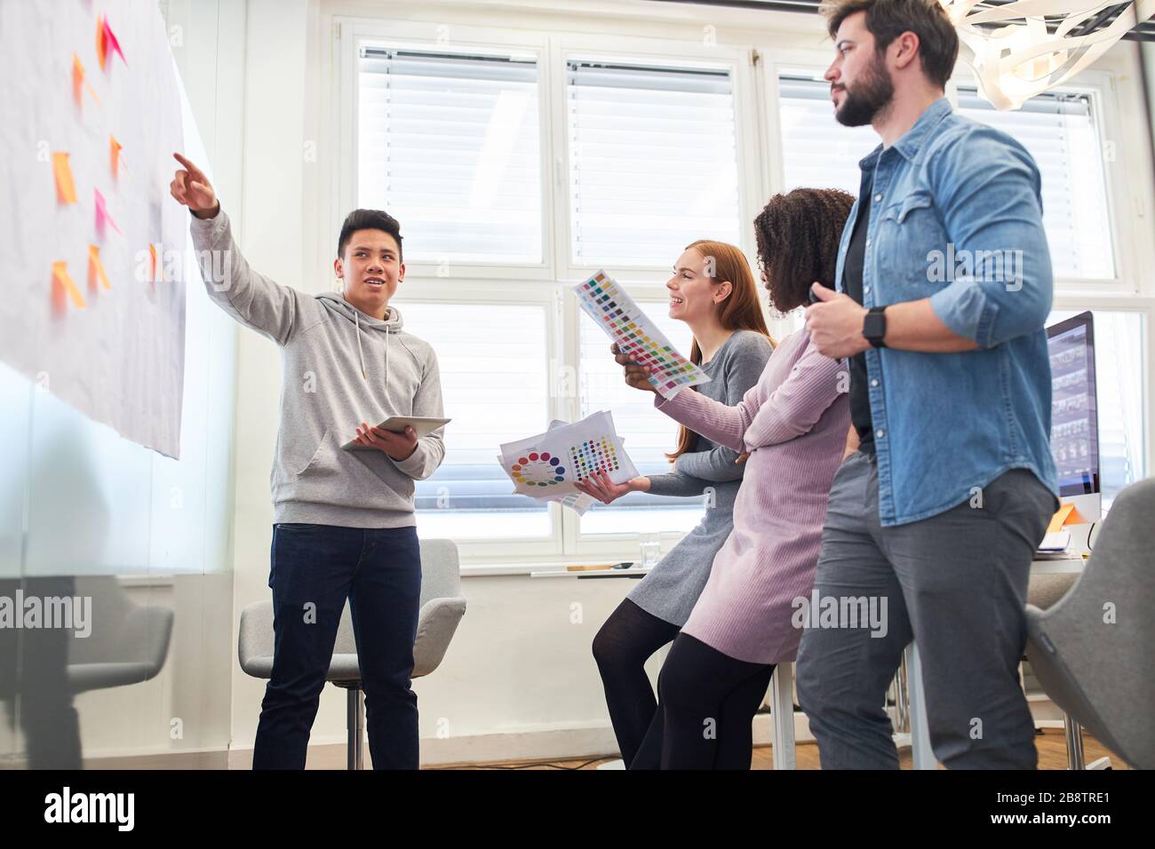 Giovane uomo come web designer con il team creativo brainstorming con note appiccicose Foto Stock