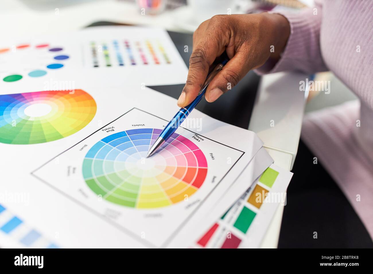 Mano da grafico con design di colore con ruota di colore sulla scrivania Foto Stock