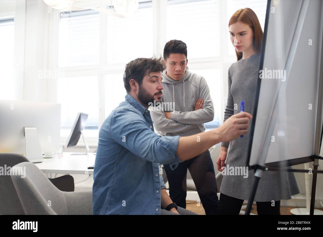 Web designer e sviluppatori Web come team durante la pianificazione del progetto sulla lavagna a fogli mobili Foto Stock