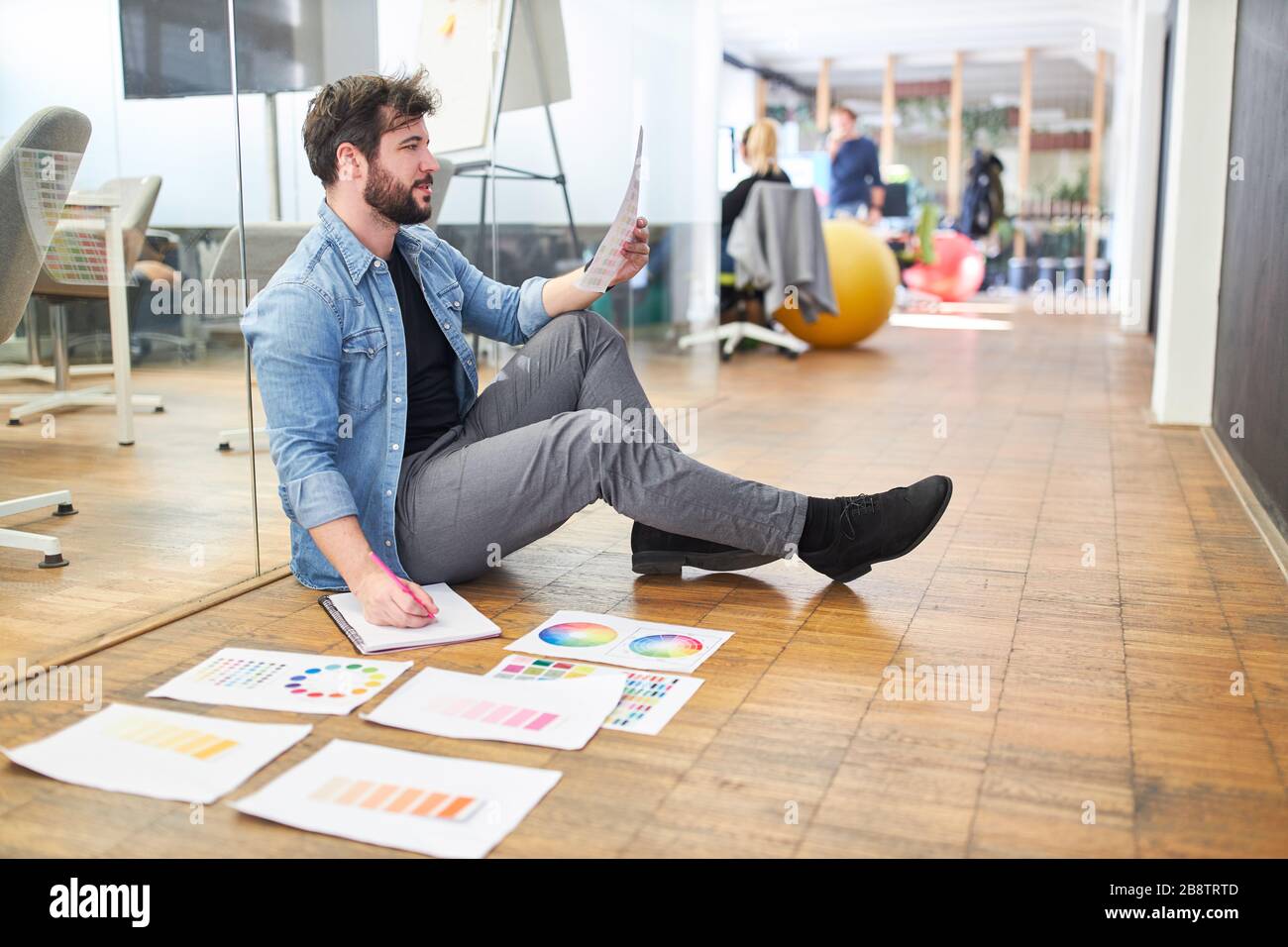 Grafico designer in un'agenzia di design che sceglie un colore per la progettazione di un sito web Foto Stock