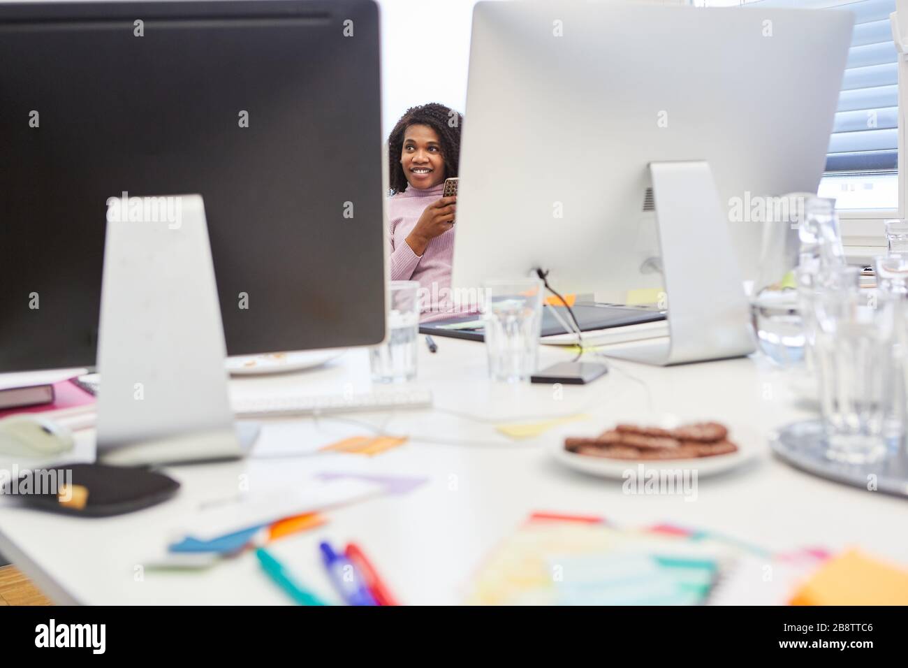 Donna africana d'affari in ufficio agenzia internet con computer a tavola Foto Stock