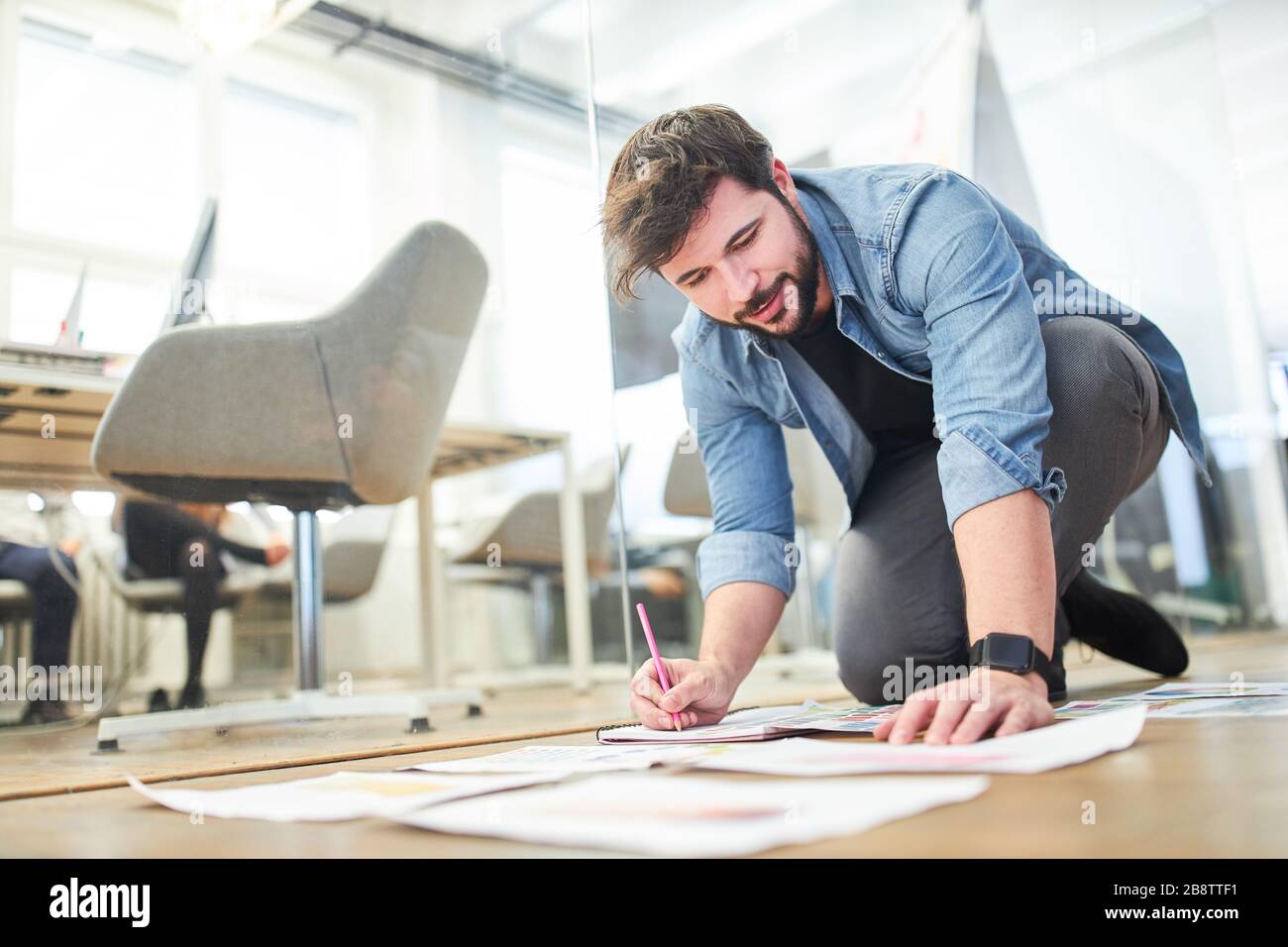 Il progettista grafico analizza i concetti di progettazione e i modelli di stampa per un progetto del cliente Foto Stock