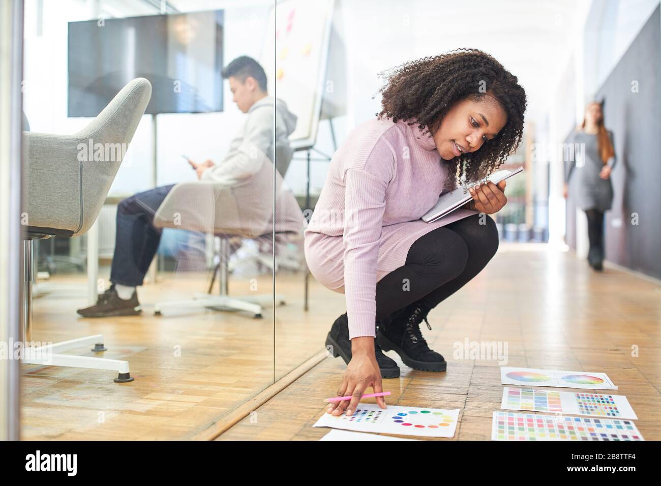 Donna africana come graphic designer che sceglie i colori nell'agenzia di disegno Foto Stock