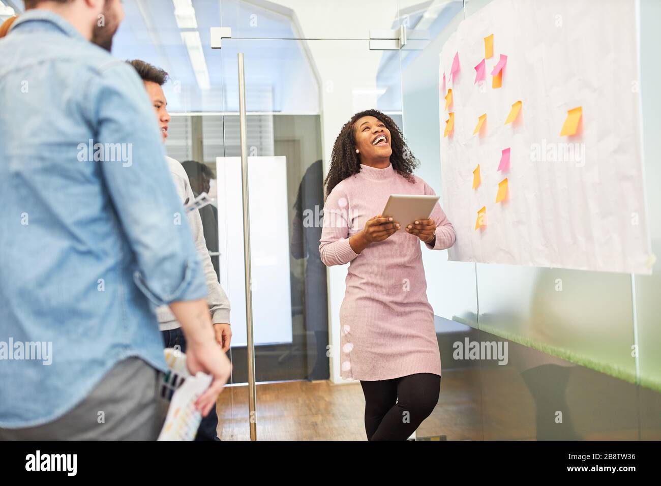 Donna d'affari africana e team creativo brainstorming con appunti appiccicosi Foto Stock