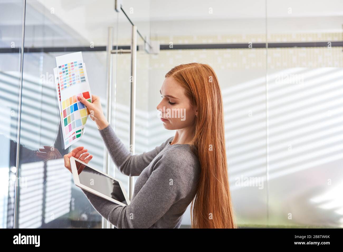 Donna come grafico designer con tablet computer controlla il colore di progettazione di un sito web Foto Stock