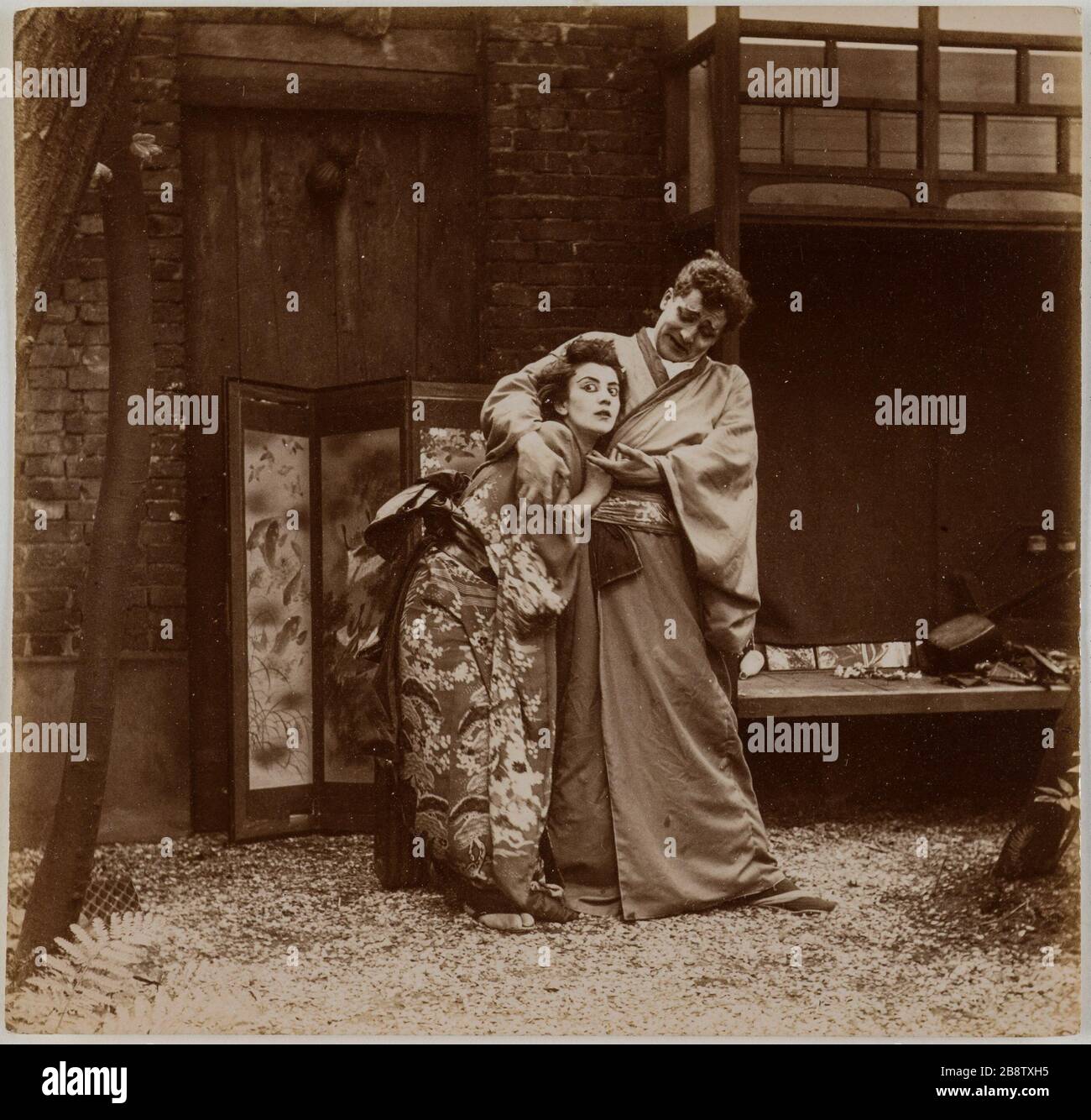 Coppia di attori in abiti tradizionali giapponesi in un giardino di fronte a uno schermo. Couple d'acteurs en costume tradizionnels japonais dans un jardin devant un paravent. Anonima fotografa, vers 1900. Parigi, musée Carnavalet. Foto Stock