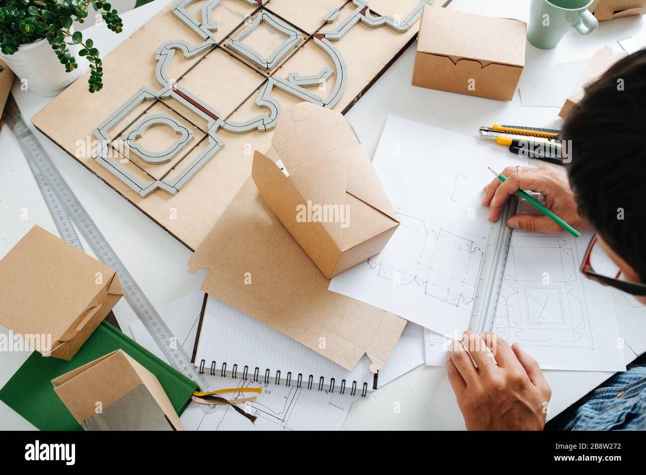 La vista dall'alto del designer di packaging sul luogo di lavoro. Foto Stock