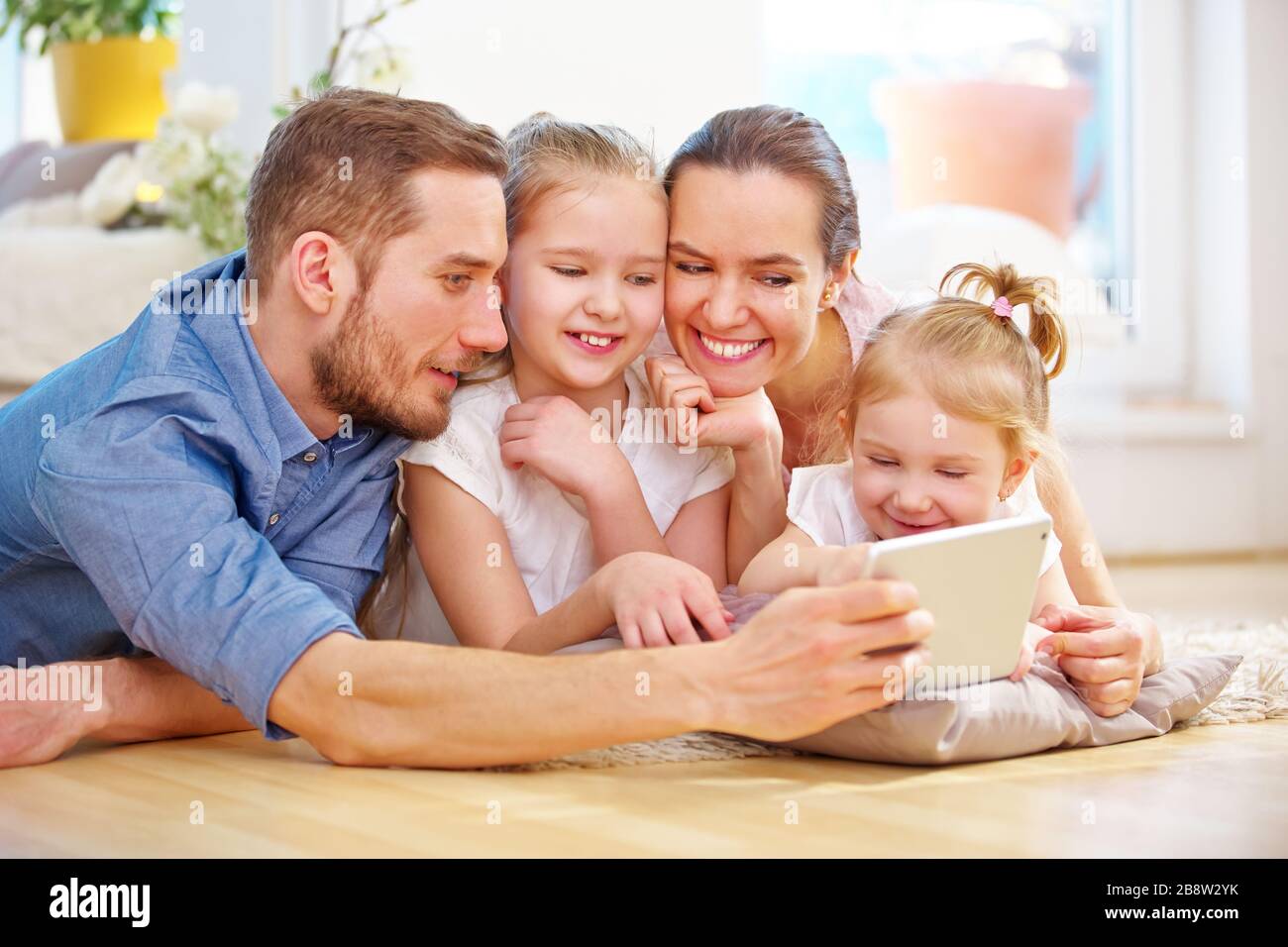Famiglia e bambini felici che utilizzano un tablet pc su Internet a casa Foto Stock