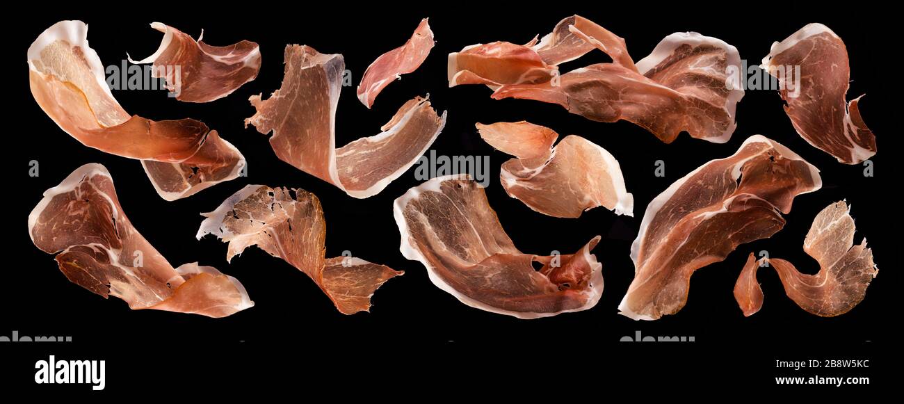 Jamon a fette, prosciutto crudo italiano secco, prosciutto spagnolo su fondo nero Foto Stock