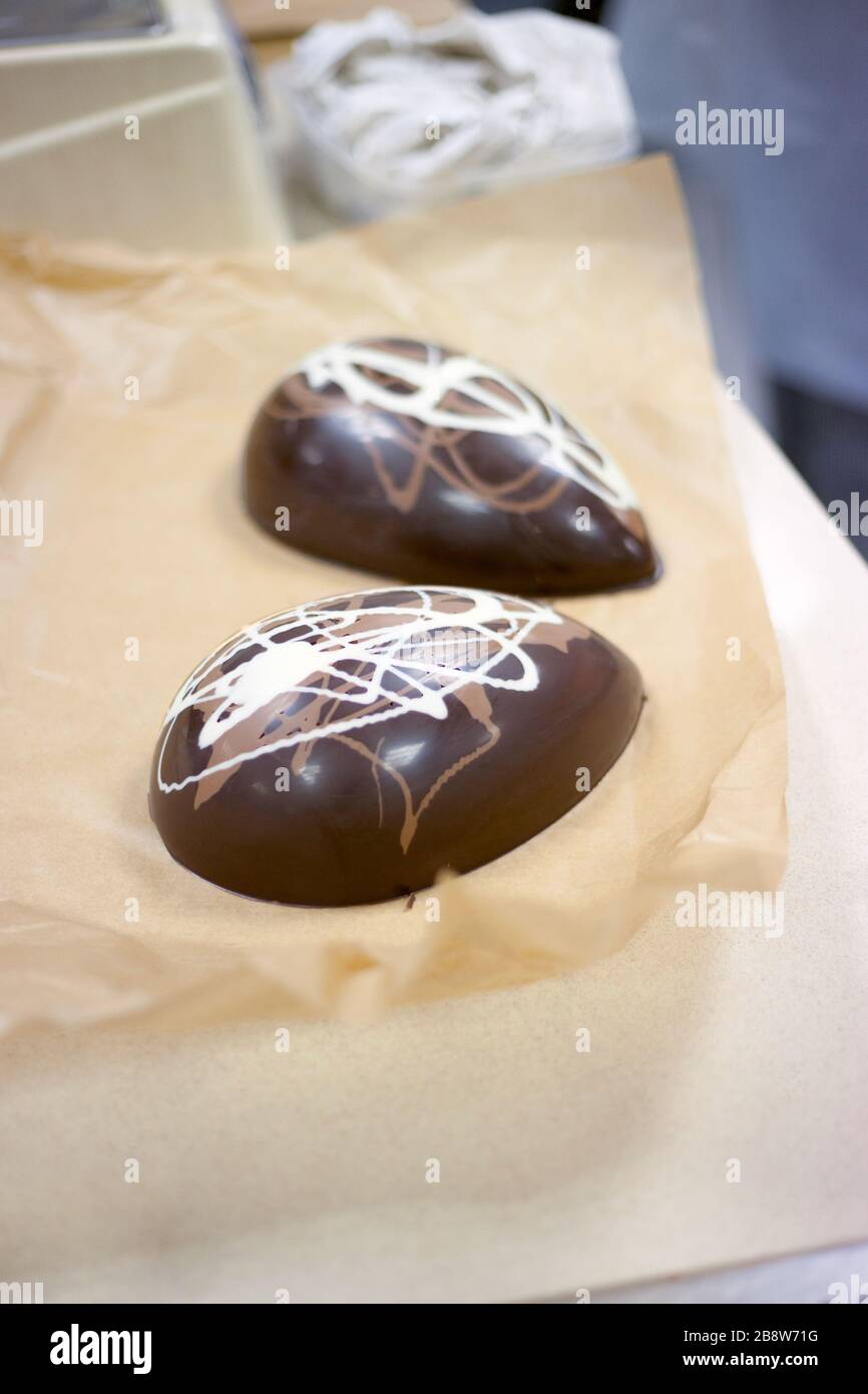 Fare il cioccolato. Preparare le uova di pasqua al cioccolato. Fabbrica di cioccolato. Foto Stock