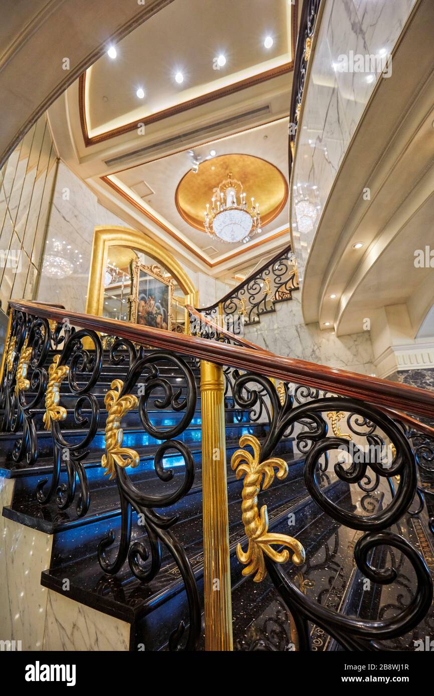 Scala a chiocciola con ringhiere ornate nell'Hotel Lisboa. Macao, Cina. Foto Stock