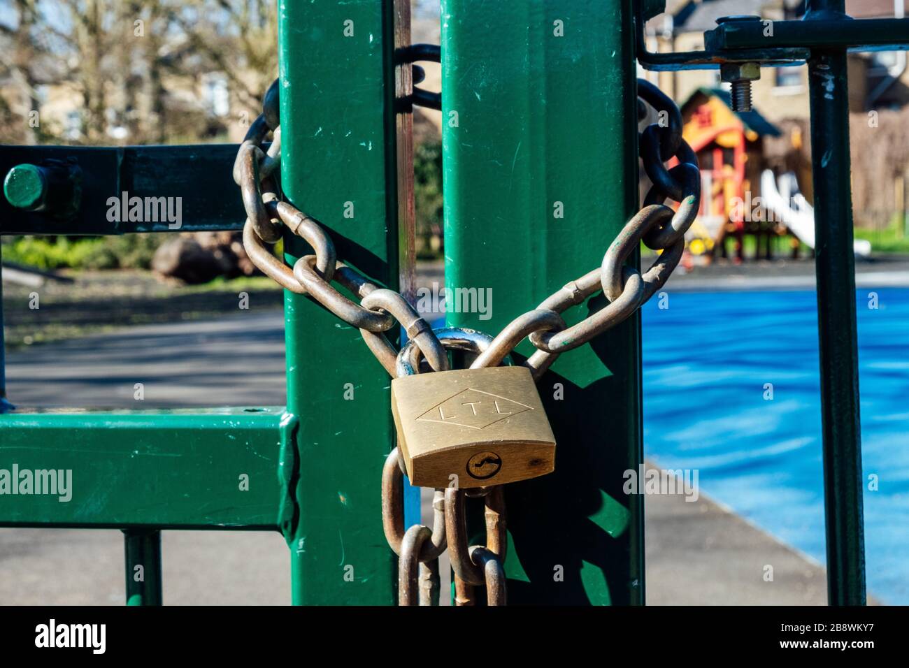 Brunswick Park, Camberwell, Londra, Regno Unito. 23 marzo 2020. Lucchetti su un cancello parco giochi. A tutti i parchi giochi di Southwark fu ordinato di essere chiuso dal consiglio il 22 marzo 2020 per contribuire a prevenire la diffusione del Coronavirus. Credito: Tom Leighton/Alamy Foto Stock