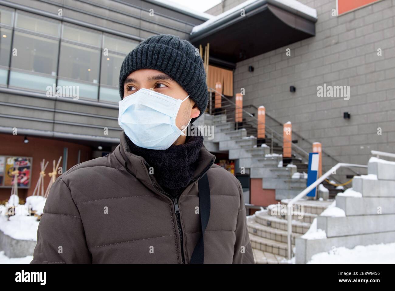 Uomo turistico asiatico che indossa maschera di protezione Coronavirus durante l'inverno in Giappone Foto Stock
