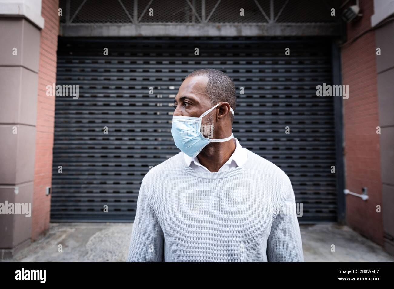 African American con maschera coronavirus covid19 in strada Foto Stock