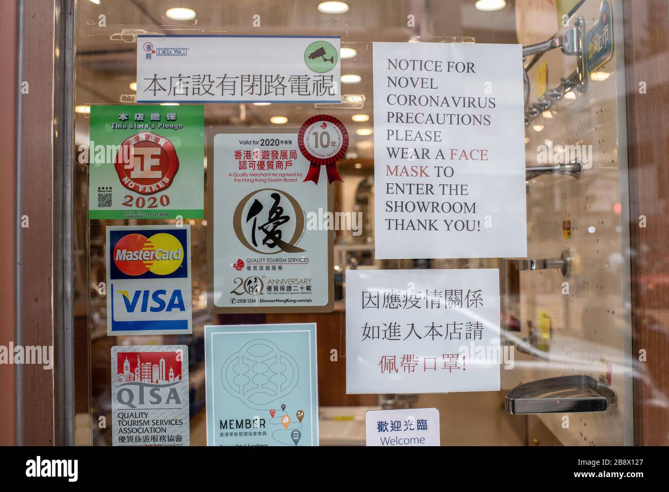 Hong Kong, Cina. 16 Marzo 2020. Un avviso che informa i clienti di indossare le maschere si trova all'interno di un negozio nel distretto di WAN Chai a Hong Kong.man mano che la pandemia di coronavirus peggiora, milioni di persone stanno lottando per adattarsi alla loro nuova realtà. Le precauzioni sanitarie, l'uso di maschere negli spazi pubblici e le quarantena sono alcune delle misure governative e autoimposte. L’Organizzazione Mondiale della Sanità ha definito un’emergenza sanitaria globale, invertendo le precedenti decisioni sull’epidemia di coronavirus. Credit: Ivan Abreu/SOPA Images/ZUMA Wire/Alamy Live News Foto Stock