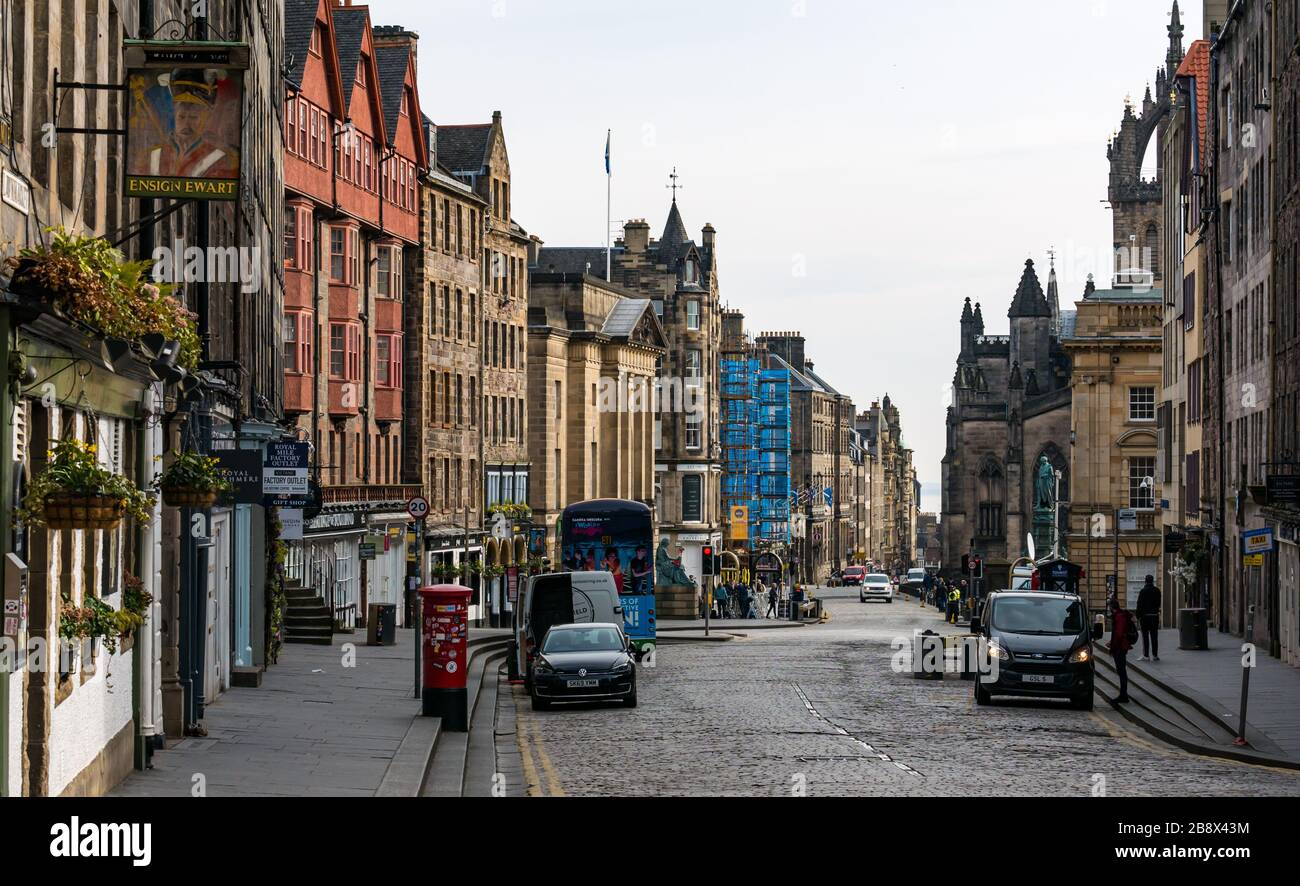 Edimburgo, Scozia, Regno Unito. 23rd marzo 2020. Strade vuote durante il Covid-19 Coronavirus pandemic nella capitale come il messaggio di prestare attenzione alle misure di distanziamento sociale sembra avere avuto un effetto nonostante il bel sole di primavera. Il Lawnmarket sul Royal Mile è abbandonato a parte gli equipaggi e i fotografi visibili più in basso lungo la strada fuori dalla High Court in attesa del verdetto di prova di Alex Salmond Foto Stock